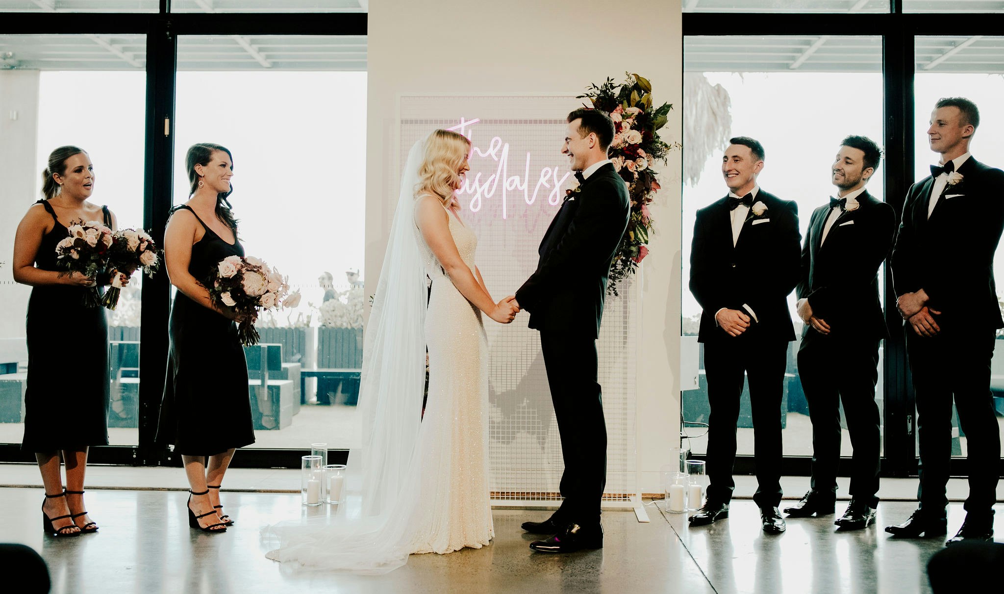 Wedding couple laughing with wedding party.